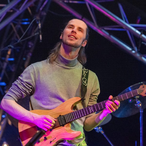 Johannes Granroth soittaa kitaraa lavalla värivalojen loisteessa