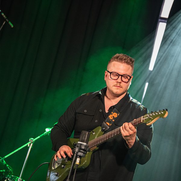 Petri Havukainen soittaa kitaraa vihreässä valossa Acoustic Bike -yhtyeessä